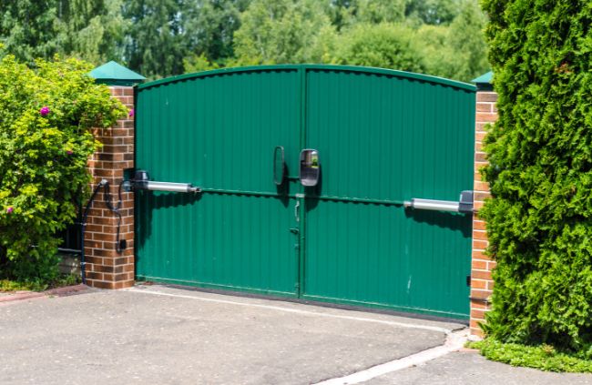 Motorised swing gate system installed by Auto Gate Guys Sydney, featuring green double gates and brick pillars for a secure driveway entrance Motorised swing gate system installed by Auto Gate Guys Sydney, featuring green double gates and brick pillars for a secure driveway entrance